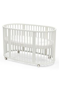 a baby crib with white sheets on the bottom and sides, in front of a white background