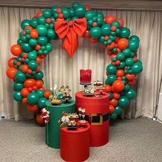 an orange, green and red balloon arch with decorations