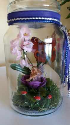 a glass jar filled with flowers on top of a table