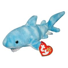 a blue shark stuffed animal with a tag in its mouth