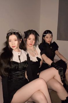 three women dressed in black and white posing for the camera