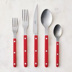 four red and white utensils with polka dots on them