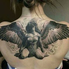 the back of a woman's neck with an angel tattoo on it