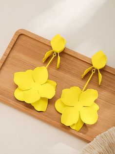 two yellow paper flowers sitting on top of a cutting board