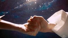 two people holding hands in front of the stars