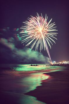 black and white photograph of fireworks on the beach