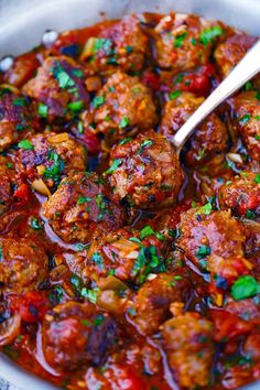 the meatballs are covered in sauce and garnished with parsley