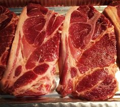 three pieces of meat sitting on top of a pan