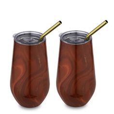 two red wine glasses with gold handles and one has a straw in the cup, while the other is empty