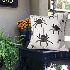 two black and white pillows sitting on top of a table next to flowers in vases