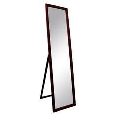 a tall mirror sitting on top of a wooden floor next to a white wall and black frame