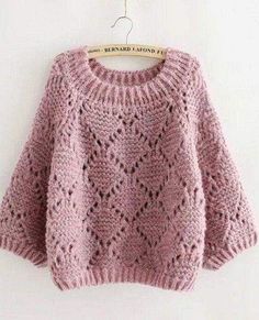 a pink sweater with an angel's logo on the front and back, hanging from a wooden hanger