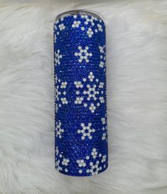 a blue and white canister sitting on top of a fur covered floor next to a wall