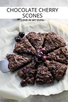 chocolate cherry scones on parchment paper with cherries in the middle and text overlay that reads chocolate cherry scones love in my oven