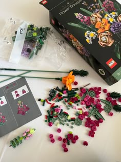 there are many flowers and beads on the table next to some crafting supplies,