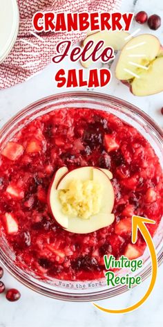 cranberry jello salad in a glass bowl with an apple slice on top