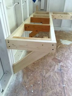 two wooden benches sitting on top of a hard wood floor next to a white door