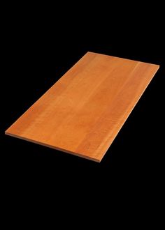 a wooden table top against a black background