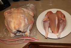 two pieces of chicken sitting on top of a white plate next to a plastic bag