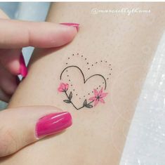 a woman's stomach with pink flowers and a heart tattoo on her left side