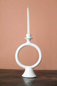 a white candle holder sitting on top of a wooden table