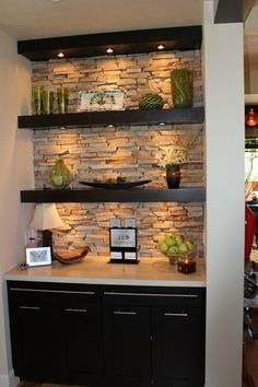 a room with stone walls and shelves on the wall, along with other items in it