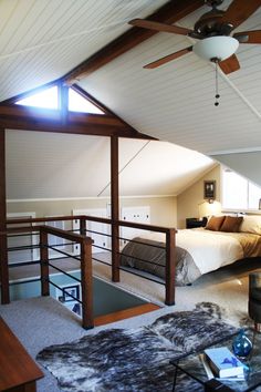 an attic bedroom with two beds and a ceiling fan