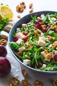 a salad with cranberries, walnuts and feta cheese in a bowl