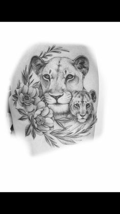 a lion and cub tattoo on the back of a woman's shoulder with flowers