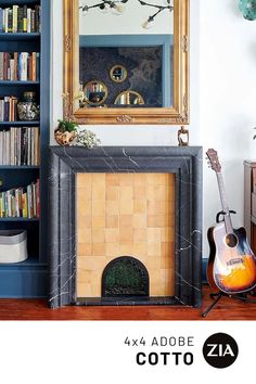 a living room with a fireplace, bookshelf and guitar in front of it