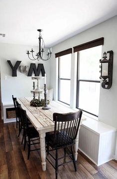 a dining room table with chairs and a chandelier hanging from it's ceiling