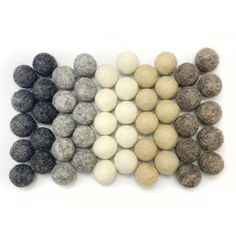 several balls of wool sitting on top of each other in different colors and sizes,