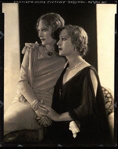 an old photo of two women sitting next to each other