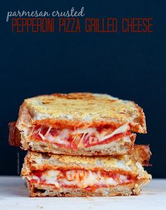 two grilled sandwiches stacked on top of each other with cheese and tomato toppings