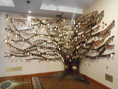 a large tree with lots of leaves hanging from it's trunk in a museum