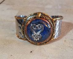 "This special piece of jewelry has a beautiful lead-free silver-pewter West African Adinkra symbol - Sankofa on a Lapis Lazuli stone. This item will add a touch of Africa to your wardrobe.  This unique and beautiful symbol is ubiquitous in Ghana. SANKOFA \"return and get it\". The symbol of the importance of learning from the past. It is by far the most popular for use in decoration, a reflection on the deeply religious character of the Ghanaian people.  Lapis lazuli or lapis for short, is a dee Artisan Ankh Jewelry For Gift, Handmade Artisan Ankh Jewelry, Straight Path, Afrocentric Jewelry, Egyptian Design, Adinkra Symbols, Beautiful Symbols, Lapis Lazuli Jewelry, Lapis Lazuli Stone