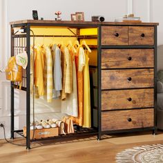 an open cabinet with clothes hanging on the rails and shoes in front of it, next to a couch