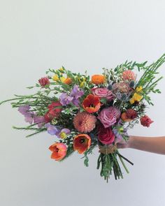 a person holding a bouquet of flowers in their hand