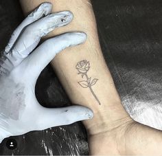 a person's hand with a rose tattoo on their left wrist and right arm