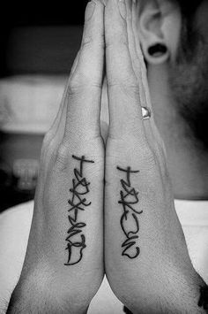 two people are holding their hands together with the word faith tattooed on their palms and fingers