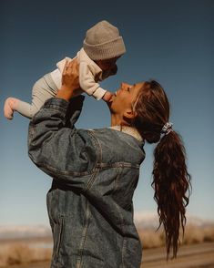 a woman holding a baby up to her face