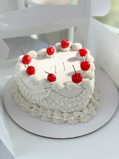 a heart shaped cake with cherries on top