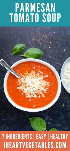 a bowl of homemade parmesan tomato soup with spinach leaves on the side