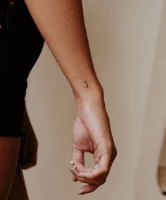 a woman's hand with a small tattoo on it