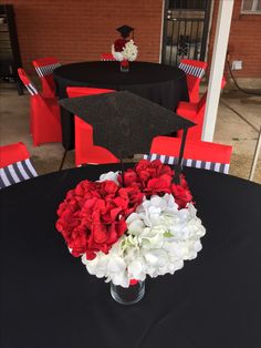 a black table topped with red and white flowers