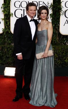 a man and woman in formal wear standing on a red carpet