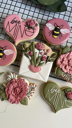 decorated cookies with flowers and hearts on a cooling rack