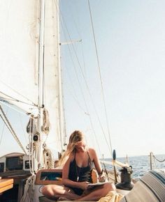 a woman sitting on the deck of a sailboat