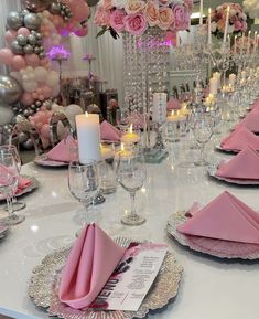 the table is set with pink napkins and place settings