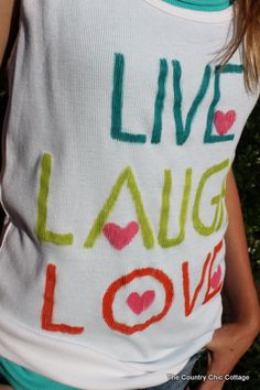 a woman wearing a tank top with the words live laugh love written on it